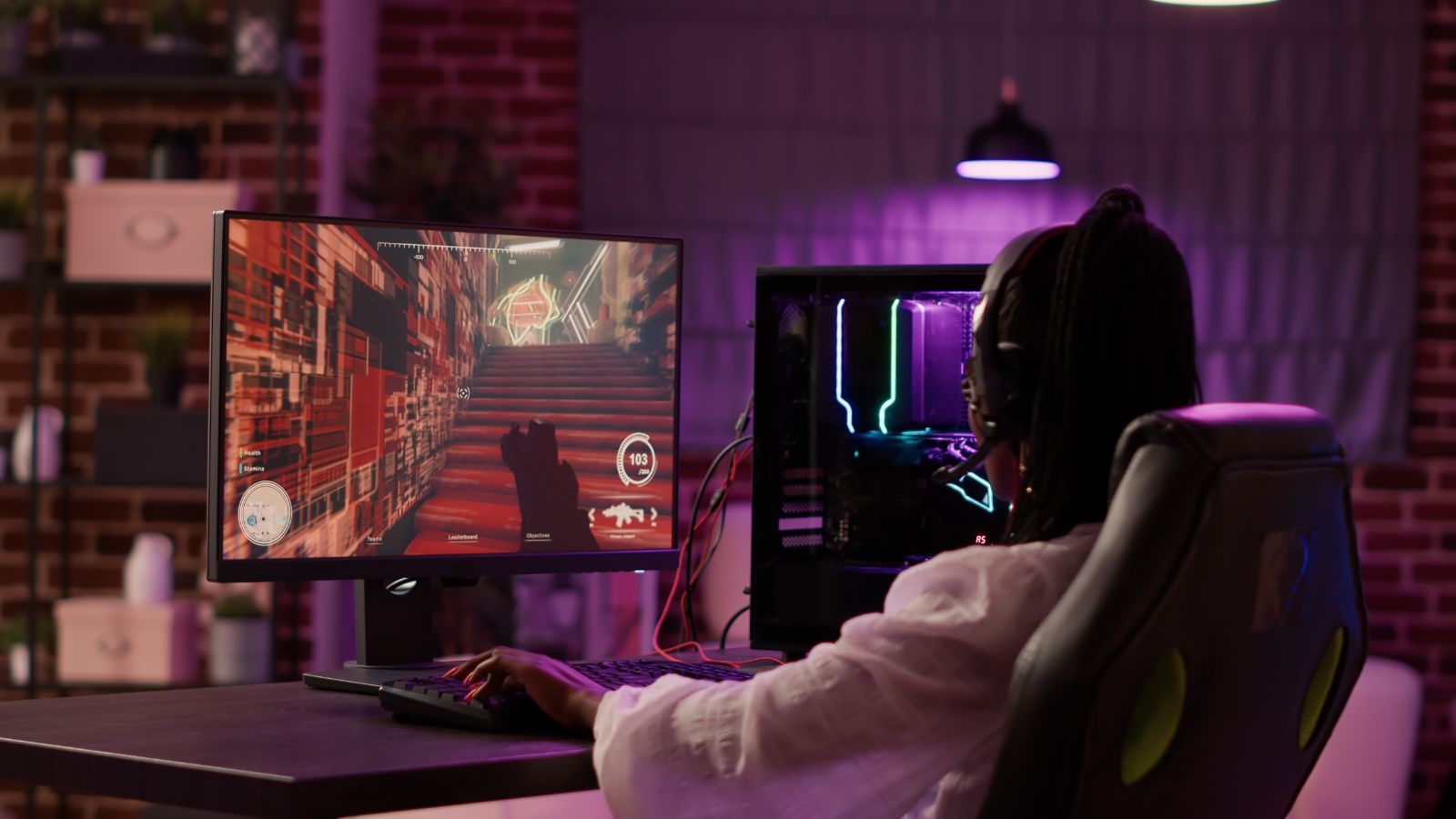 Rear view of a gamer playing an online game at a gaming desk